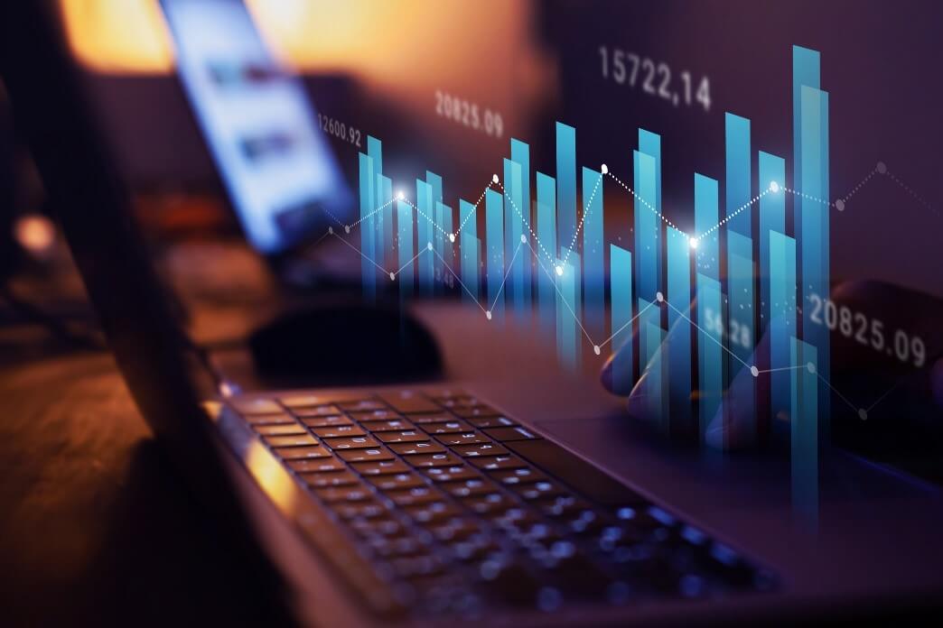 A close-up of a laptop keyboard with an overlay of digital bar graphs and data, representing innovative IT strategies and business growth.